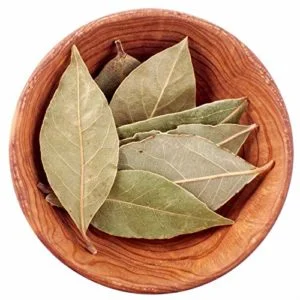 A wooden bowl filled with dried bay leaves from DM Traders Organic store.
