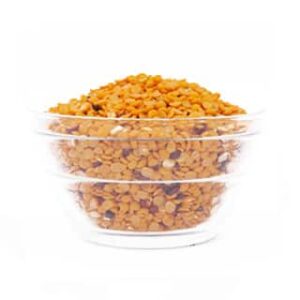 A Glass Bowl Filled With Red Lentils From Dm Traders Organic Store.