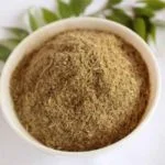 Bowl Of Kabasura Kudineer Powder With Green Leaves In The Background. Kabasura Kudineer